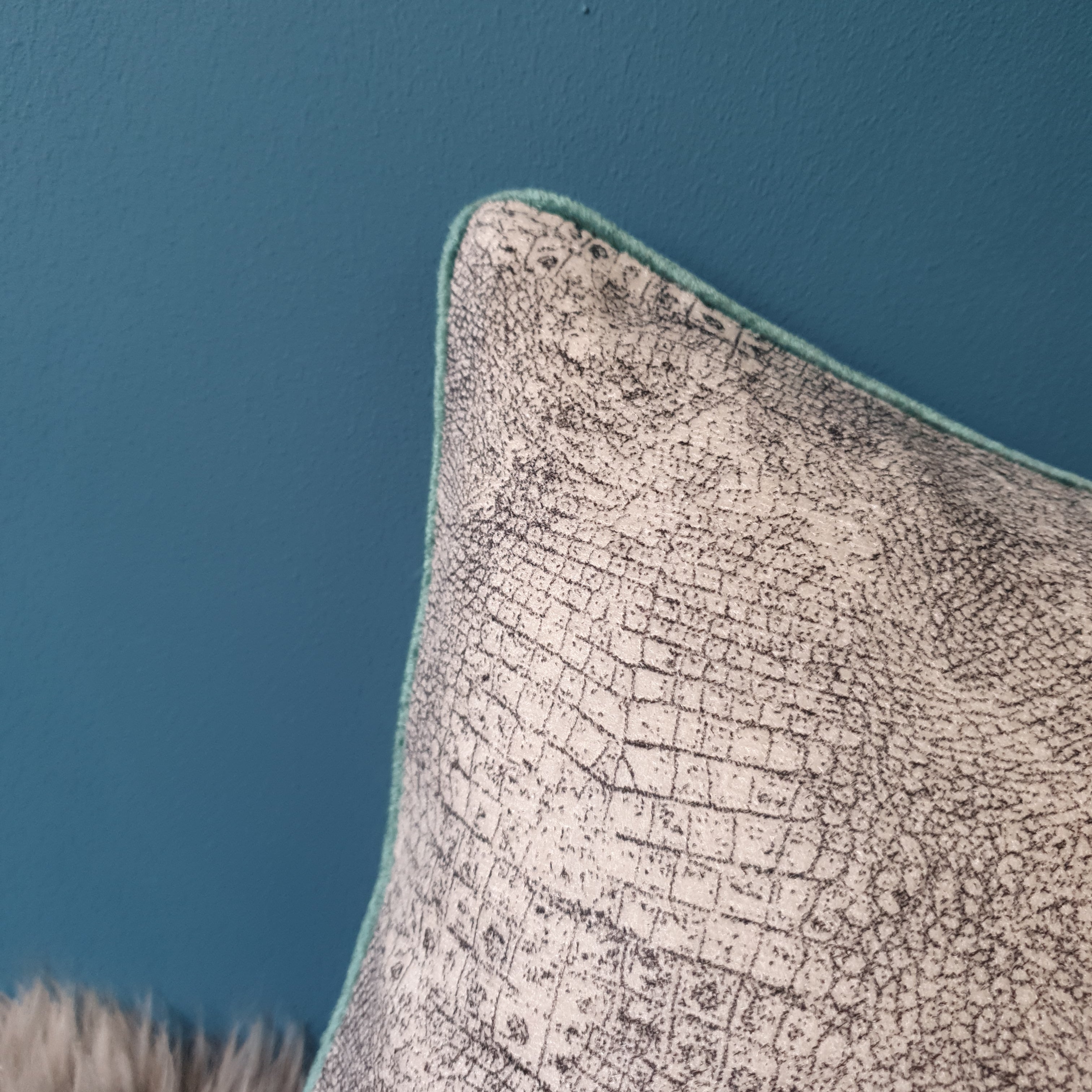 Abstract animal print velvet cushion with seafoam velvet piping